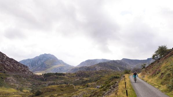 A Cyclist riding along a gravel trail in the Welsh mountains
