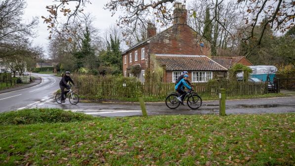 Three cyclists cycling on a road in Norfolk © Jason Bye