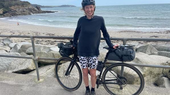 Katy Rodgers stood with bike in front of the sea