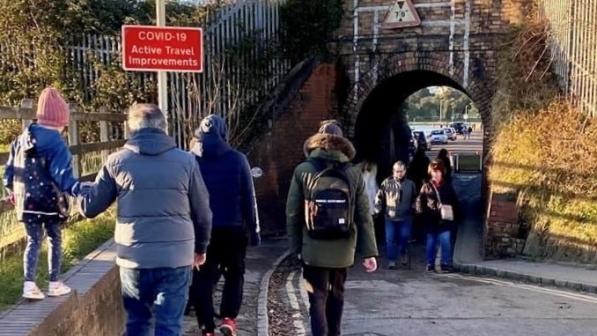 Pedestrians waiting to pass under keyhole bridge after it reopened to traffic