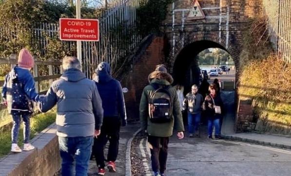 Pedestrians waiting to pass under keyhole bridge after it reopened to traffic