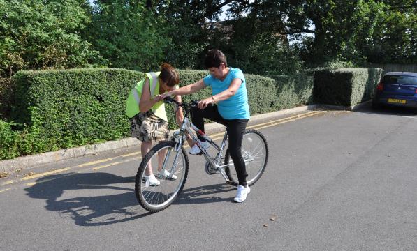 Julie teaching Alicia to ride a bike 