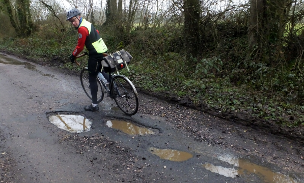 Cyclist by a pothole in Devon