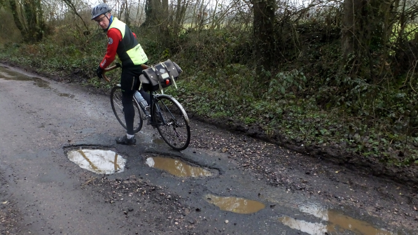 Cyclist by a pothole in Devon