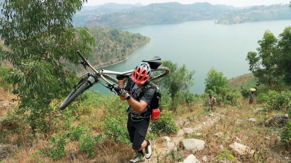 William Tucker carries his bike over rough terrain