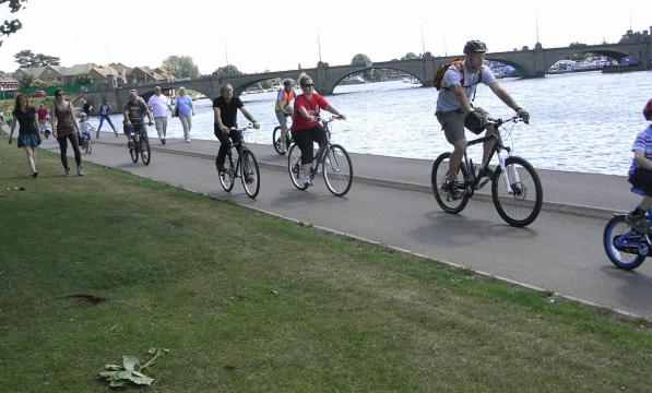 cyclists riding by waterside