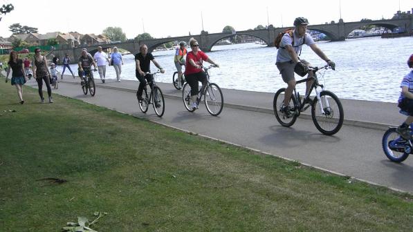 cyclists riding by waterside