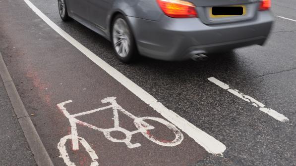 Car driving next to cycle lane