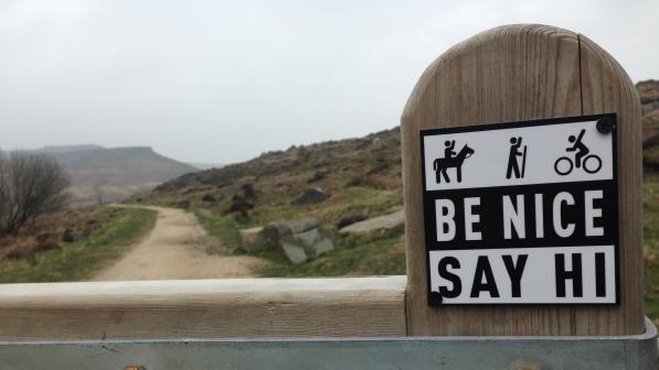 Be Nice Say Hi sign on fence post