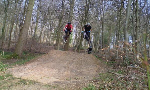 Riders from Bike Park Bishopstoke jumping over a dirt jump