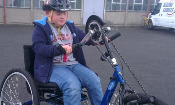 A young boy riding a hand trike