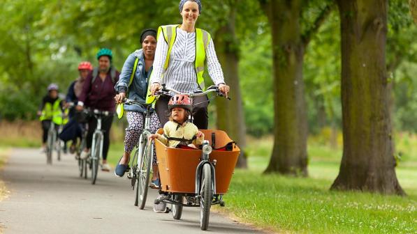 Sarah riding a cargo bike with child in the front