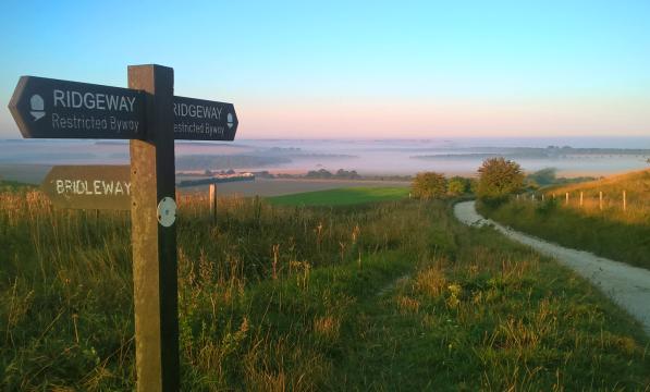 Finger post on the Ridgeway National Trail with hills in distance