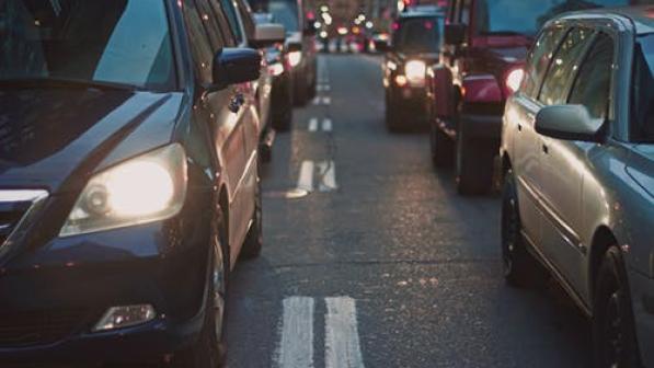 Cars queue in traffic on a road at night