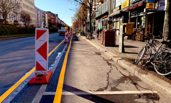 A yellow line and bollards denote a cycle path in Berlin
