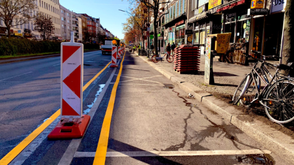 A yellow line and bollards denote a cycle path in Berlin