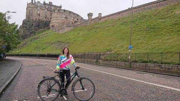 Woman with bike standing on road under Edinburgh Castle