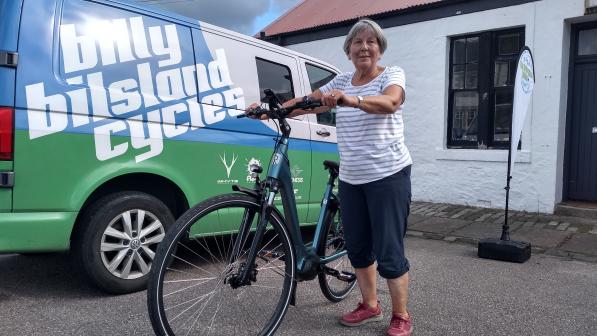 Woman with bike standing in front of building