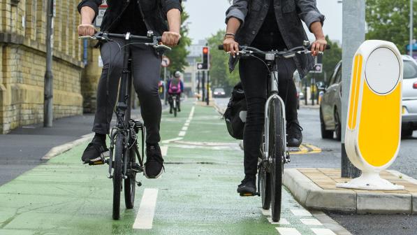 Two people cycling along a cycle lane 