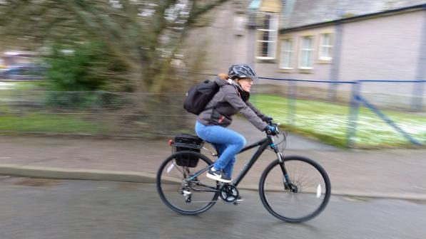 woman in urban area riding bike with blurred background