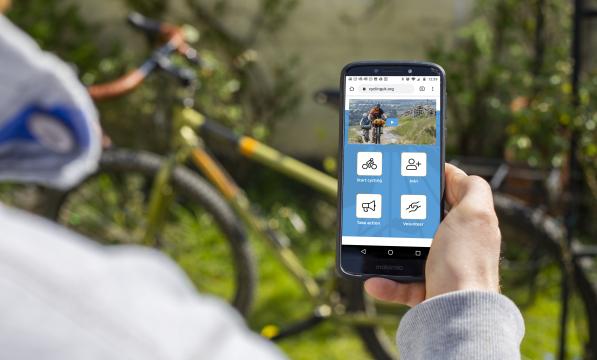 Anonymous person looking at Cycling UK website on smartphone