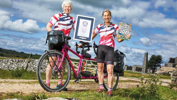 Two ladies stand by a tandem holding a Guinness World Record