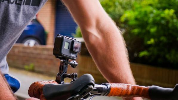 A cyclist using a camera mounted on their handlebars