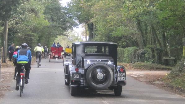 Cyclist and veteran car on a country lane