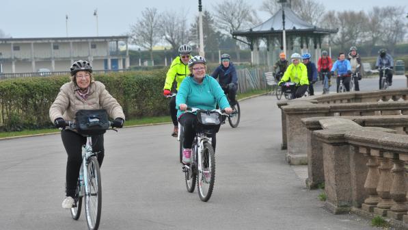 a varied group of people cycling together