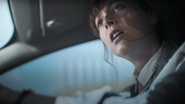 Woman looks in shock out of a car window