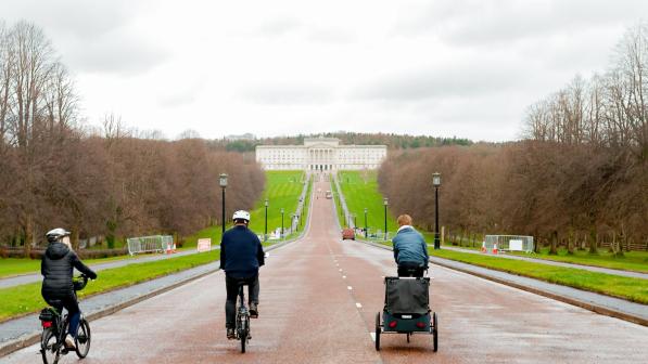 Three cyclists on the long road in front of Stormont, Belfast