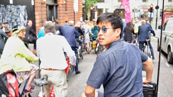 A group of cyclists, the one in the foreground is looking over his shoulder