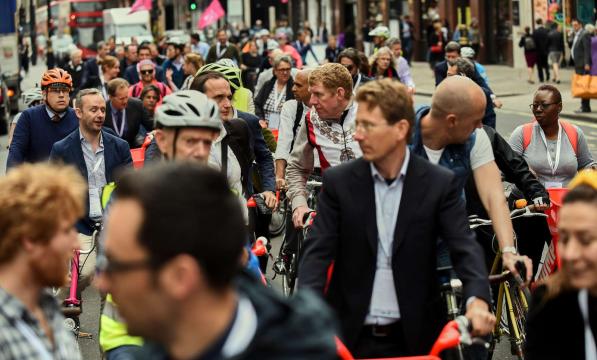 A large group of cyclists in ordinary clothes waiting to start on a mass ride