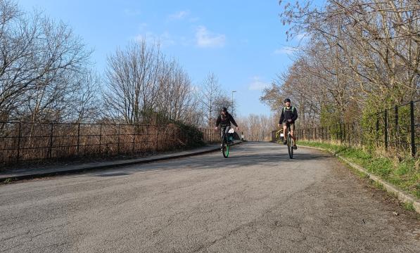Two unicyclists riding on large wheels