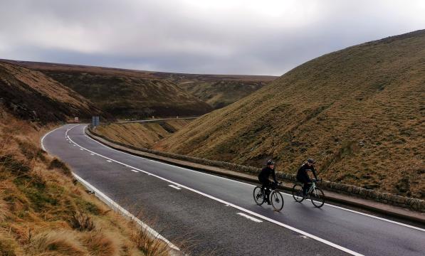 A pair of cyclists ride up the traffic free Snake Pass