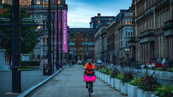 man cycling past planters in George Square, Glasgow