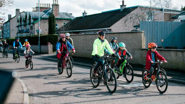 Photo of families riding along a residential road
