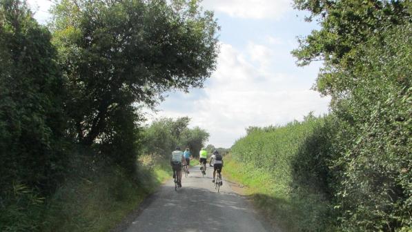 People cycling down a country lane