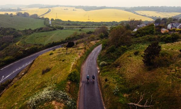 Drone shot of people cycling along a country lane in Kent