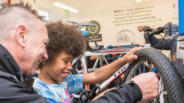 A man and a boy changing a bicycle tyre