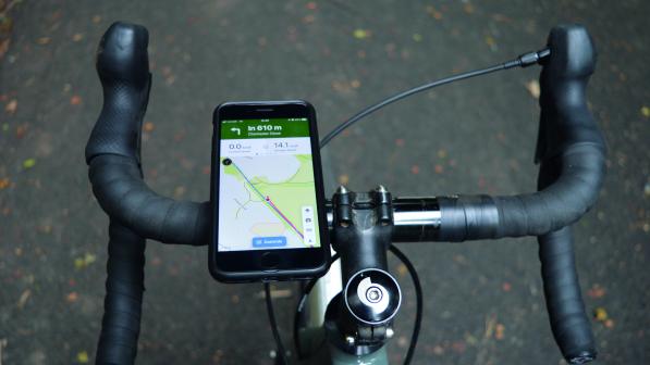 Point of view of a bicycle's handlebars, a phone is mounted to the left hand side, a map showing the route to follow