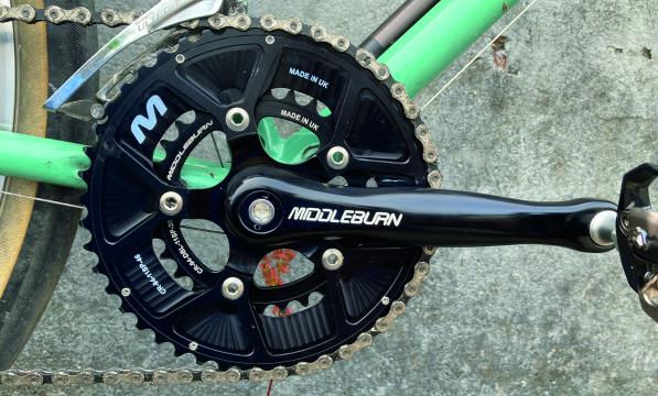 The black chainset and crank of a bicycle