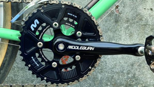 The black chainset and crank of a bicycle