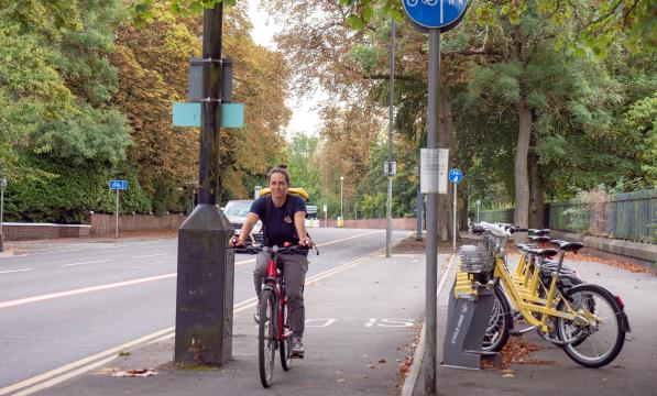 woman cycling towards camera in city cycle lane