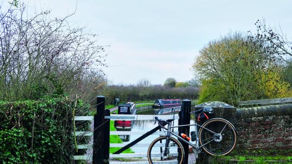 A bike leans against a brick wall overlooking a canal