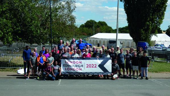 A large group of people stand behind a banner which reads London Edinburgh London 2022