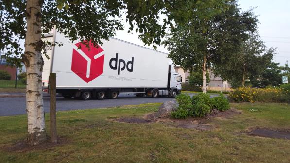 A large lorry in on a small, local road