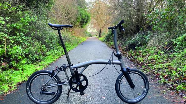 A foldable bicycle stands on a cycle path