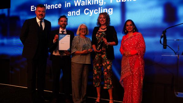 Anna Vince from Cycling UK and representatives from Aberdeenshire Council standing on stand being presented with an award