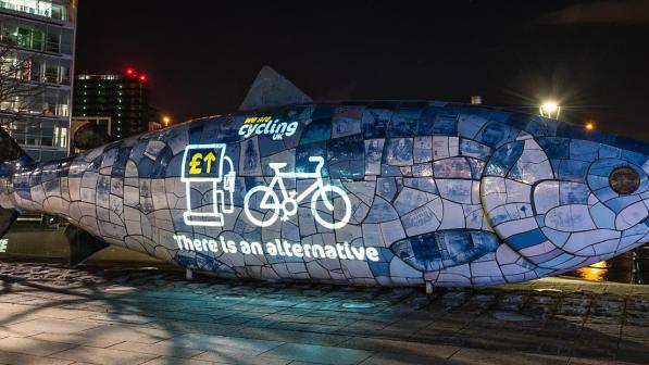 A projection of a cycle on a sculpture of a fish